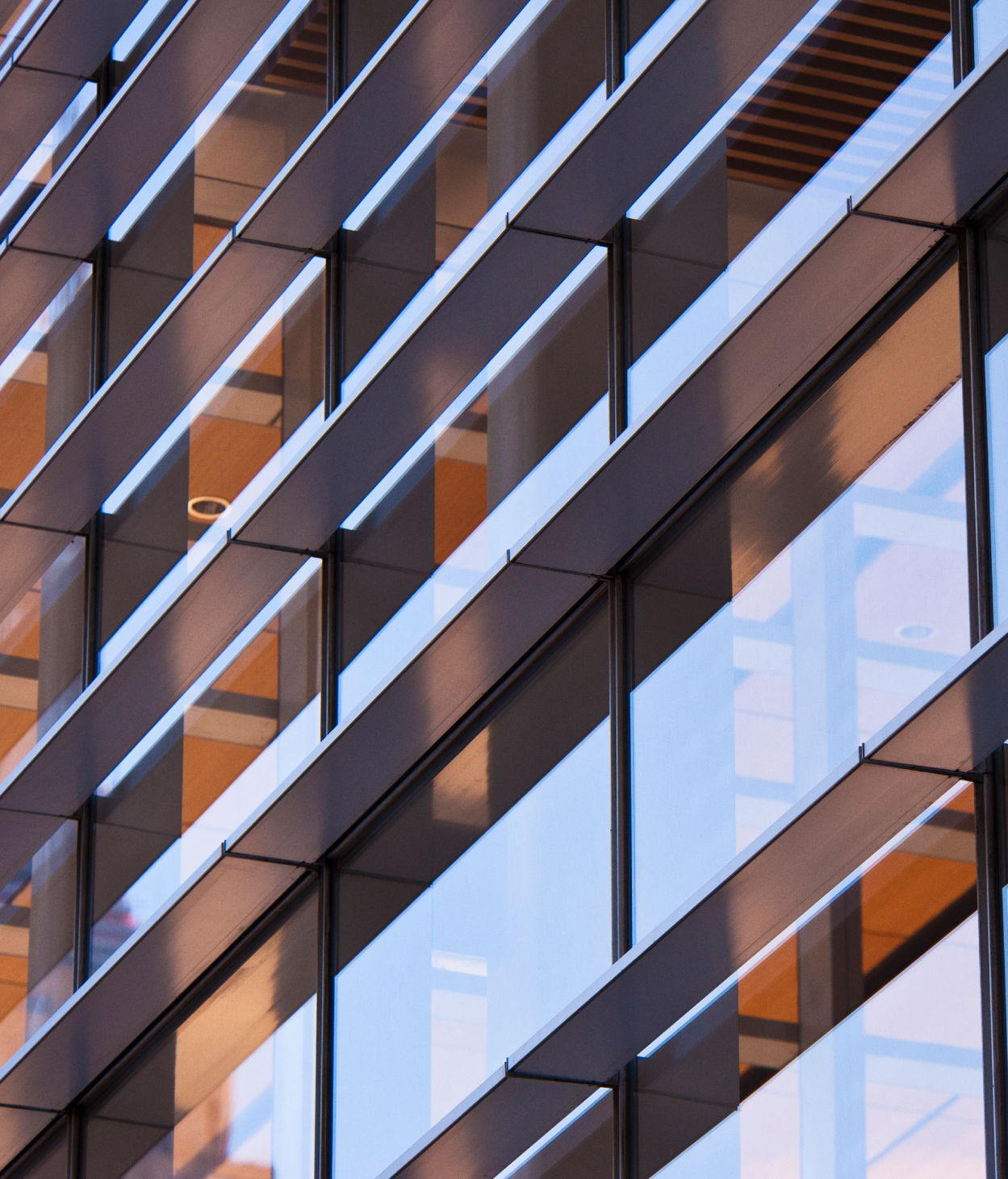 Closeup of an office building where the interior can be seen through the windows.